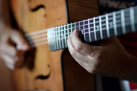 Close-up of a hand on the fretboard of a guitar