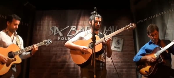Lorenzo Spini on stage between two other guitarists at the Six Bars Jail folk club